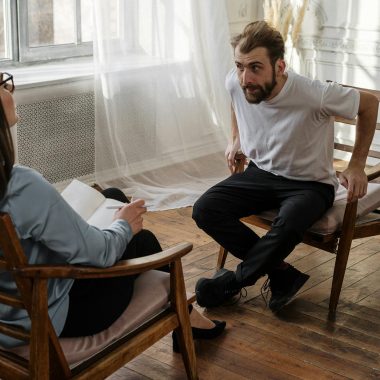 A therapist engages with a male patient in a counseling session.