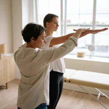 A therapist helps a client with therapeutic exercises in a wellness clinic.